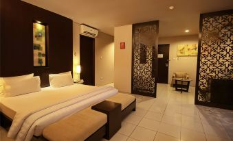 a large bed with white linens is in a room with a brown bench and a gray accent wall at The Pade Hotel
