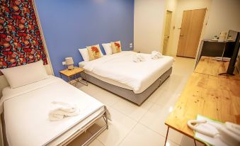 a modern hotel room with white beds , blue walls , and wooden furniture , including a table and nightstands at IRabbit Hotel