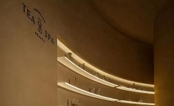 There is a room with shelves and wall lights, next to which there is an illuminated bar at Guangzhou Tianhe TaiKoo Hui James Joyce ELITE Hotel