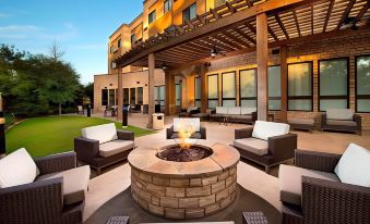 a patio area with a fire pit surrounded by chairs and couches , creating a cozy atmosphere at Courtyard Lufkin
