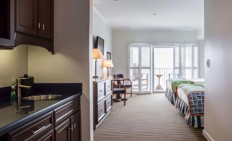 a modern , well - lit hotel room with large windows and a balcony , featuring a kitchenette and dining area at Island Inn & Suites, Ascend Hotel Collection