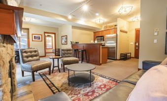 a modern living room with various furniture , including couches , chairs , and a dining table , as well as a kitchen area with a stove at The Village at Palisades Tahoe