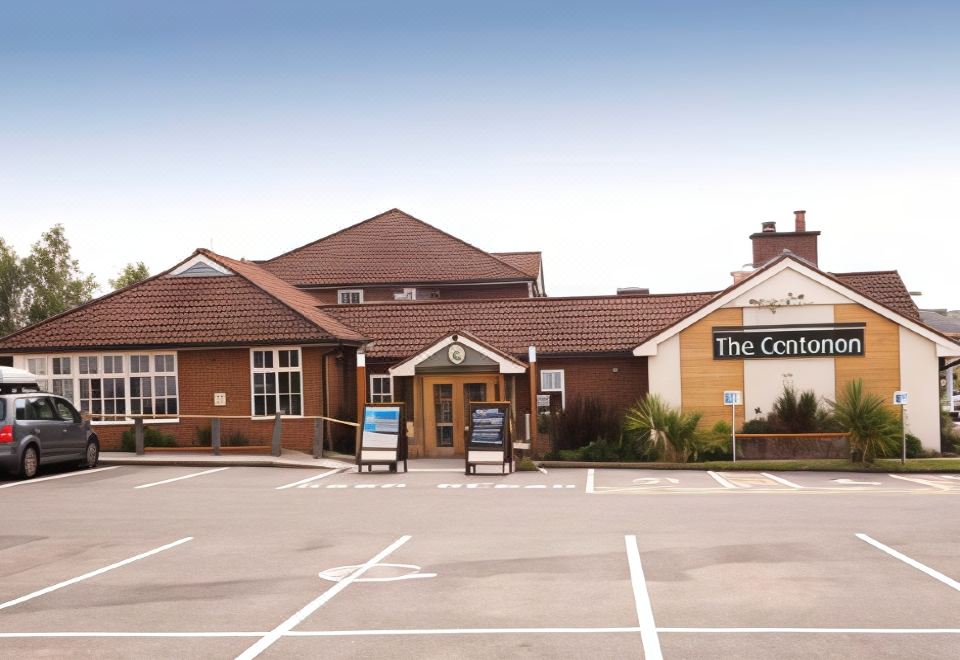 "a large building with a sign that says "" the centre "" is surrounded by parking spaces" at Premier Inn Tamworth South