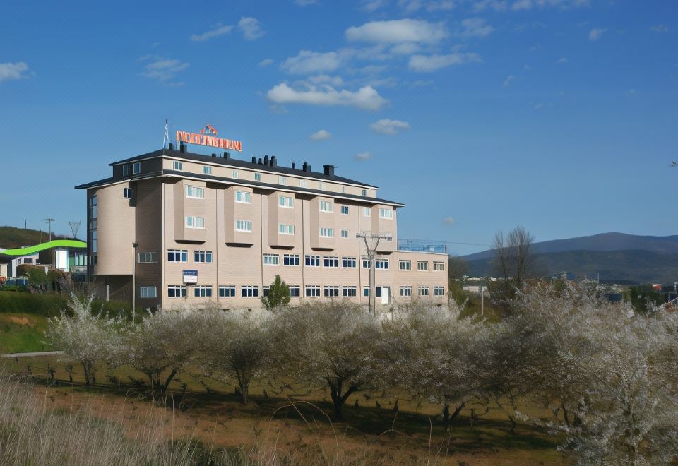 "a large building with the word "" hotel "" written on it , surrounded by a grassy field and trees" at Hotel Novo