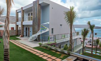 a modern , white building with a unique design and a winding staircase leading up to it at Elounda Orama