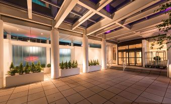 a modern building with a large glass atrium , featuring white columns and a tiled floor at Hotel NoMa, Trademark Collection by Wyndham