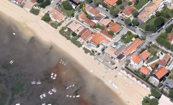 a bird 's eye view of a beach with houses and boats on the shore near the water at Les Flots Bleus