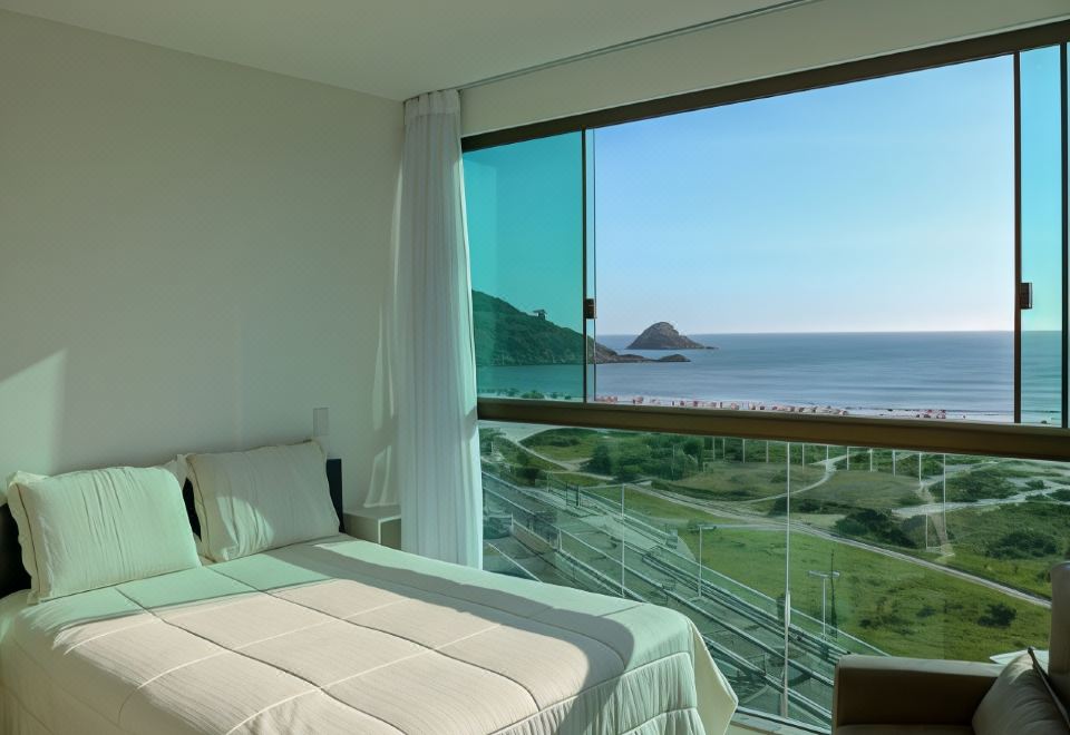 a bedroom with a large window overlooking the ocean and a bed with white linens at Sophia II Residence Inn