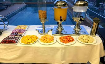 A table in the main dining hall of the hotel's buffet is set with plates and food at Aaron Vientiane Hotel