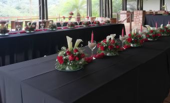 a long table with a black tablecloth and red candles , set for a formal dinner at Hotel Mountain Paradise