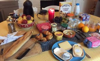 a dining table with a variety of food items , including bread , fruits , cheese , and other snacks at La Terrasse, Centre St-Antonin