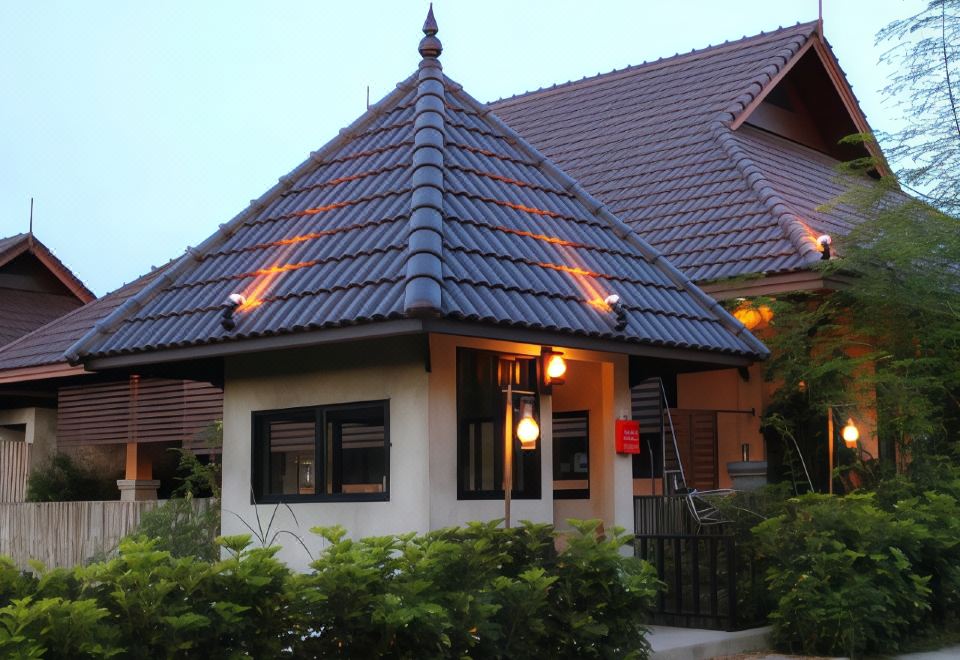 a large house with a blue tiled roof and a red lantern on the front porch at Chalicha Resort