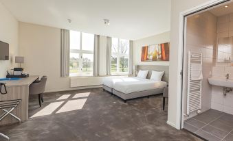 a modern hotel room with two beds , large windows , and a painting on the wall at Fletcher Kloosterhotel Willibrordhaeghe