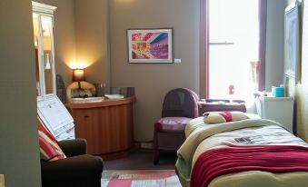 a small hotel room with two beds , a desk , and a chair , all arranged in the same space at Balch Hotel