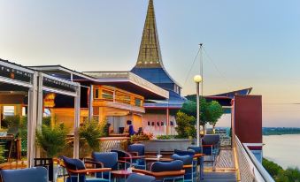 a rooftop bar with several tables and chairs , as well as a large martini glass on the table at Blu Hotel