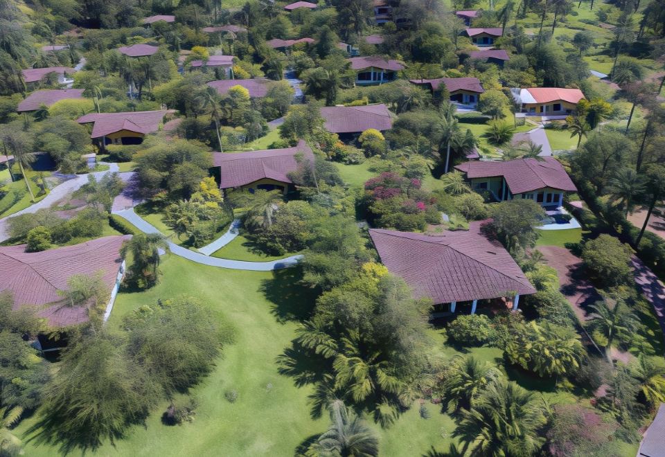 aerial view of a residential area with houses and trees , surrounded by green grass and bushes at Hotel Mountain Paradise