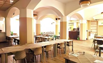 a large dining room with multiple tables and chairs arranged for a group of people to enjoy a meal together at Hotel Touring