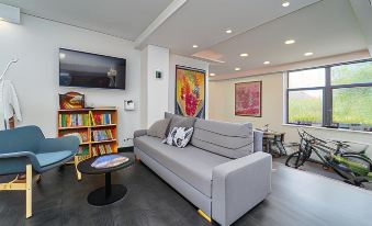 a modern living room with a large grey couch , bookshelf , and artwork on the wall at Vincent