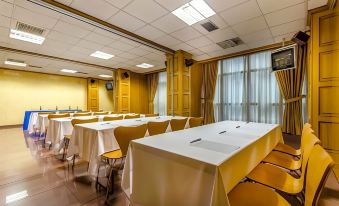 a conference room set up for a meeting , with several tables and chairs arranged in rows at Hotel Princess