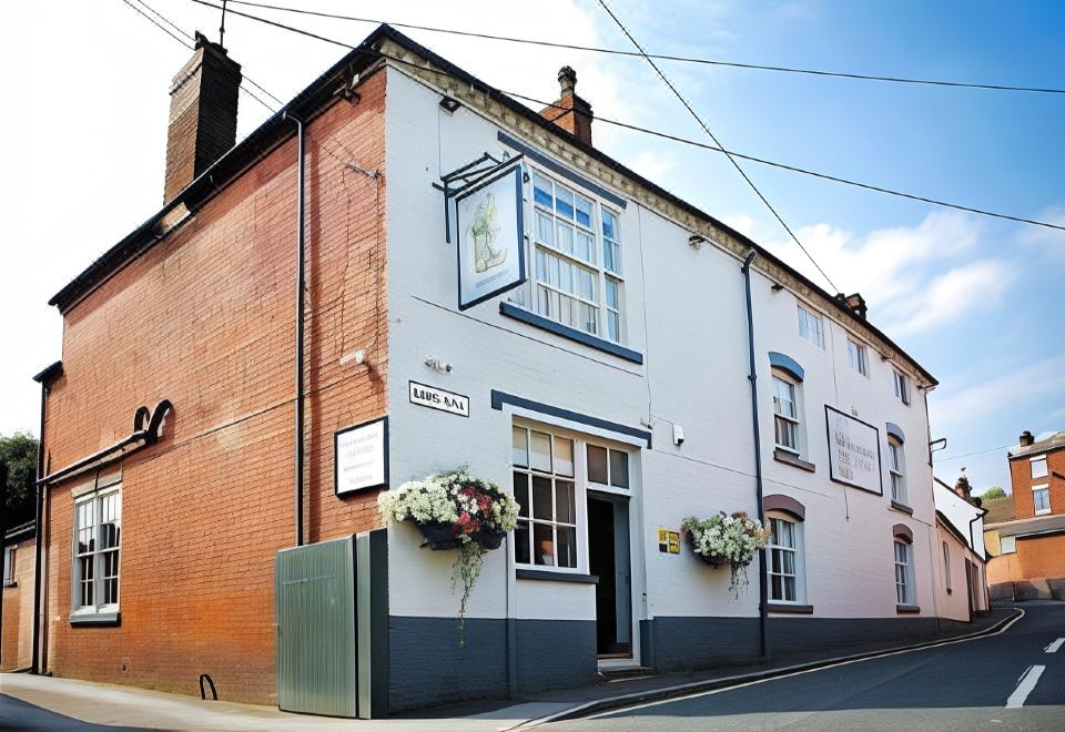 a brick building with a sign on the front , located on a city street corner at The Boot Inn