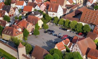 a bird 's eye view of a city with red - roofed buildings and a parking lot filled with cars at Akzent Hotel Schranne