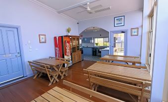 a room with wooden benches and a coca - cola vending machine , possibly in a school setting at Waterview Gosford Motor Inn