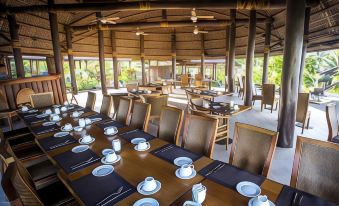 a long dining table set for a large group of people , with several chairs arranged around it at Sinalei Reef Resort & Spa