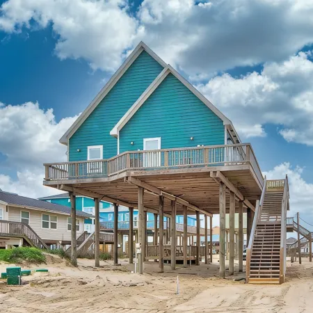 Martinis & Bikinis, a beach front house with toes in the sand drink in the hand.