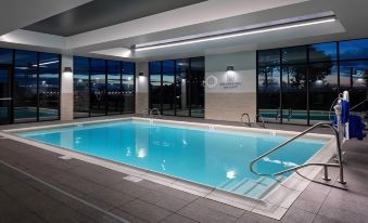 a large swimming pool with a ladder is surrounded by windows and has a logo on the wall at Courtyard Pasco Tri-Cities Airport