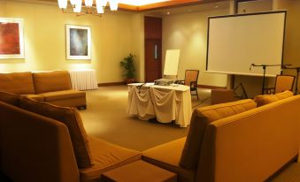a conference room with multiple chairs arranged around a table , and a projector screen on the wall at Timberland Highlands Resort