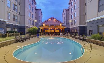 a large swimming pool with a wooden structure in the center and chairs around it at Homewood Suites by Hilton Dayton - South/Dayton Mall