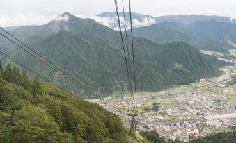 a cable car traveling through a mountainous landscape , with the city of fuzhou visible in the distance at Shosenkaku Kagetsu