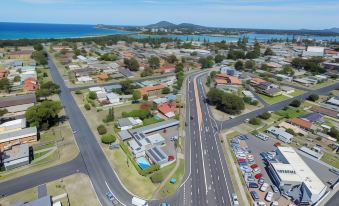 aerial view of a city with multiple buildings , roads , and a body of water in the background at Bali Hi Motel