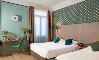 a modern hotel room with two beds , green walls , and blue accents , including a desk , chair , and vase at Hôtel le Bristol