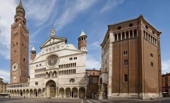 a large white building with a clock tower , situated in a square surrounded by other buildings at Hotel Continental