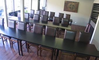 a conference room with a long table surrounded by chairs and a large painting on the wall at Morwell Motel