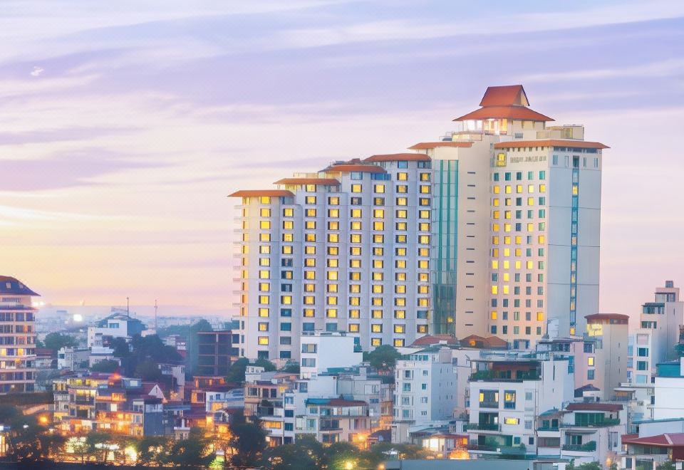 At night, there is a large illuminated building in front with the cityscape in the background at Pan Pacific Hanoi