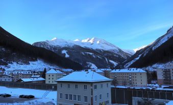 a snow - covered mountain range in the background , with a city skyline visible in the foreground at Hotel Lindenhof
