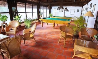 a room with a red brick floor and wooden tables , chairs , and a large window at Whale Island Resort