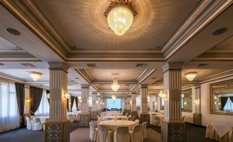 a large , elegant banquet hall with multiple round tables and chairs set up for a formal event at Majestic Hotel