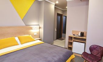 a modern bedroom with a bed , nightstands , and a desk , all decorated in gray and yellow at Luna Hotel