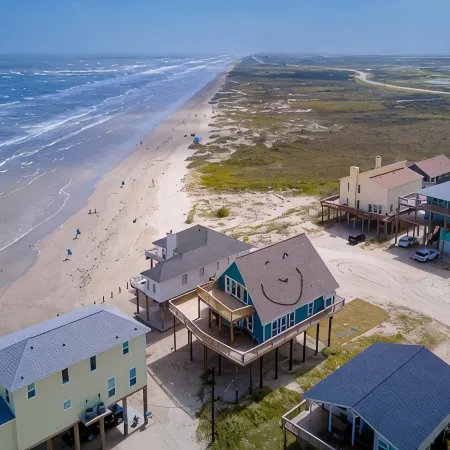 Martinis & Bikinis, a beach front house with toes in the sand drink in the hand.
