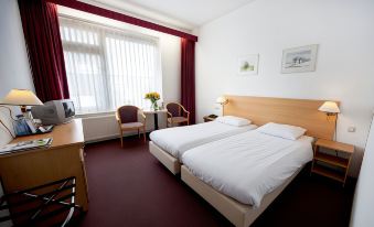 a hotel room with two beds , a desk , and a window , decorated with white linens and red curtains at Fletcher Hotel Restaurant de Gelderse Poort