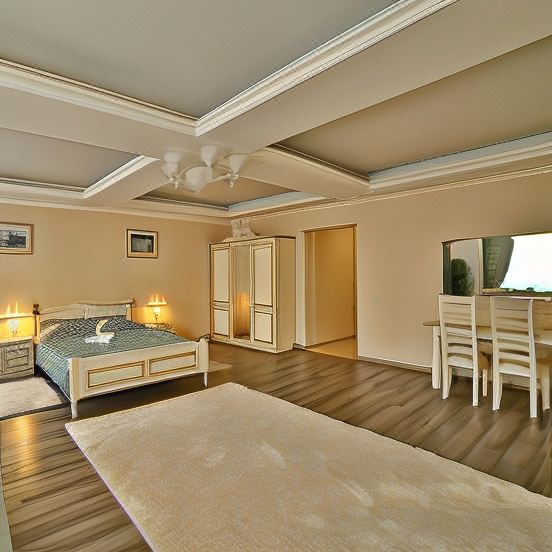 a spacious bedroom with a large bed , wooden floors , and a flat - screen tv mounted on the wall at Voyage Hotel