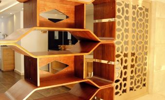 a modern bookshelf with multiple shelves , arranged in a zigzag pattern , set against a gold - colored wall at Sofi Hotel