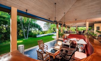 a large outdoor living area with wooden furniture and a view of a swimming pool at Boutique Hotel Luna Azul