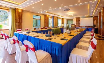 a conference room set up for a meeting , with several chairs arranged in a semicircle around a table at Aagantuk Resort