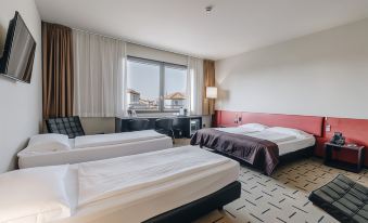 a hotel room with two beds , one on the left and one on the right side of the room at Hotel Continental