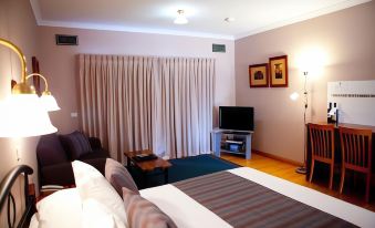 a hotel room with a bed , curtains , and a tv , giving a cozy and inviting atmosphere at Perricoota Vines Retreat