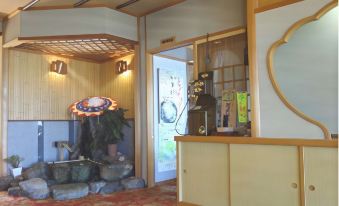 a room with a wooden floor , a sink , and a doorway leading to another area at Yamadaya